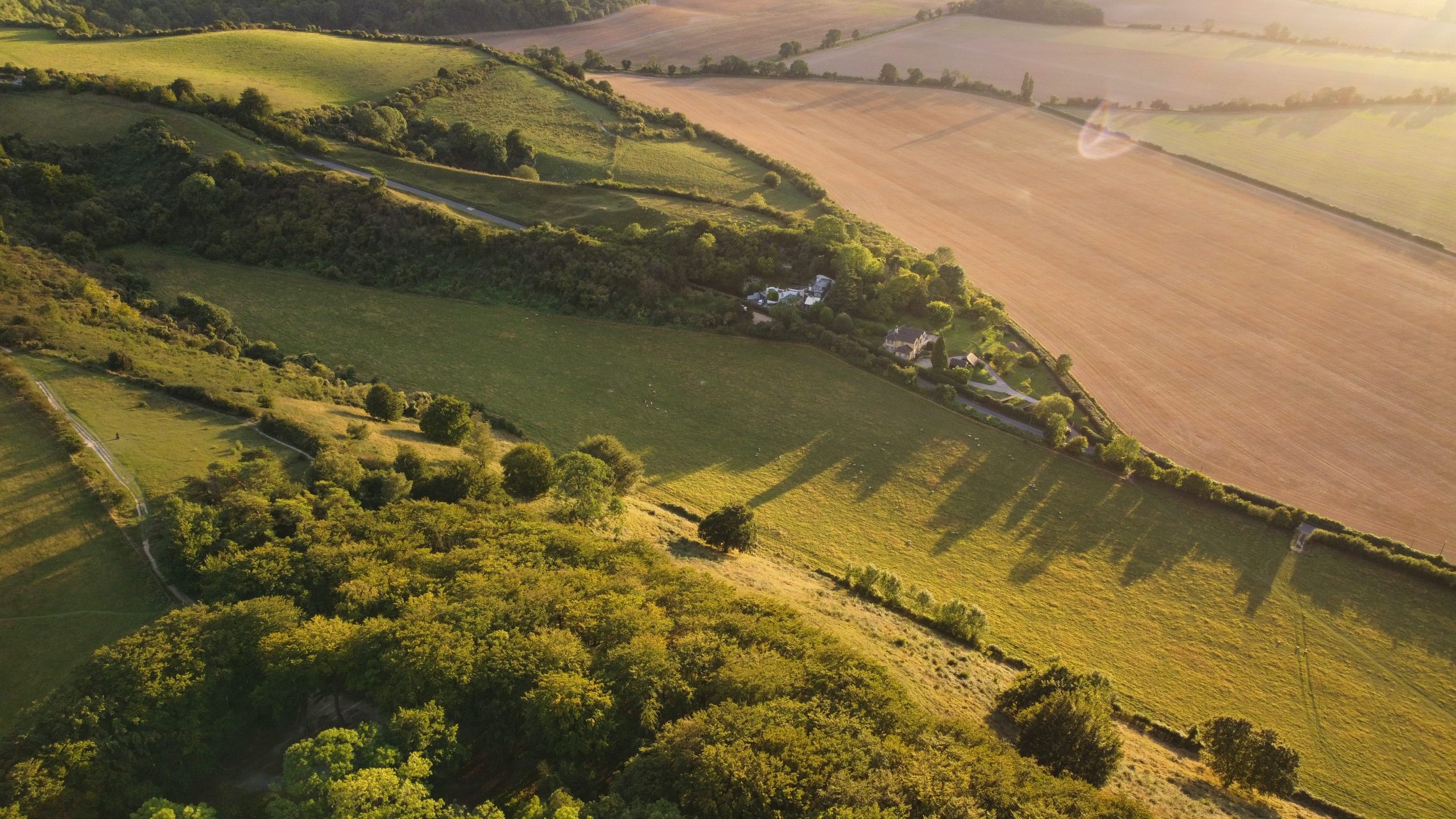 An aerial view of a farm and fields at sunset, highlighting the gap between targets and reality.