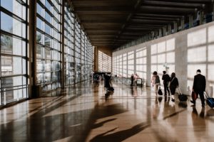 A group of people engaged in business travel walking through an airport.