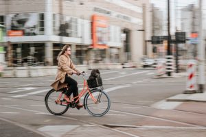 Une femme à vélo pour aller travailler dans une rue de la ville.