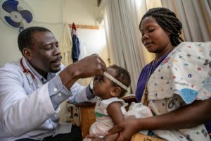 A doctor, supported by the drugs for neglected diseases initiative, examines a child in a hospital.