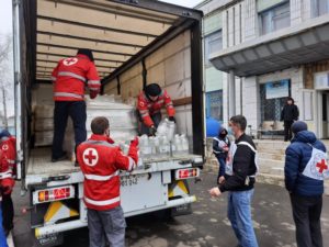 The international committee of the red cross loading a truck with supplies.