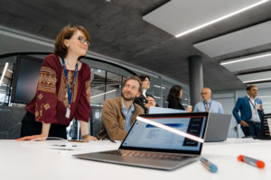 A group of people from the Geneva Centre for Security Policy standing around a table with laptops.