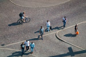 A group of people engaging in soft mobility, walking on a cobblestone street.