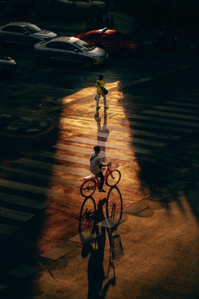 Un individu pratiquant la mobilité douce en faisant du vélo sur une rue.