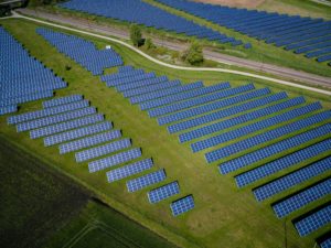 Une vue aérienne de panneaux solaires dans un champ capturant la vaste étendue d’énergie renouvelable.