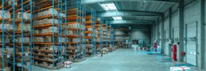 A warehouse filled with boxes and pallets, emphasizing the need to request carbon reductions at the supplier level.