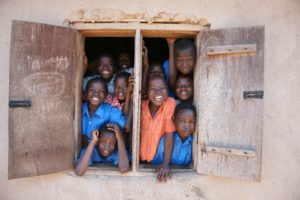 A group of children in a target sectors looking out of a window.