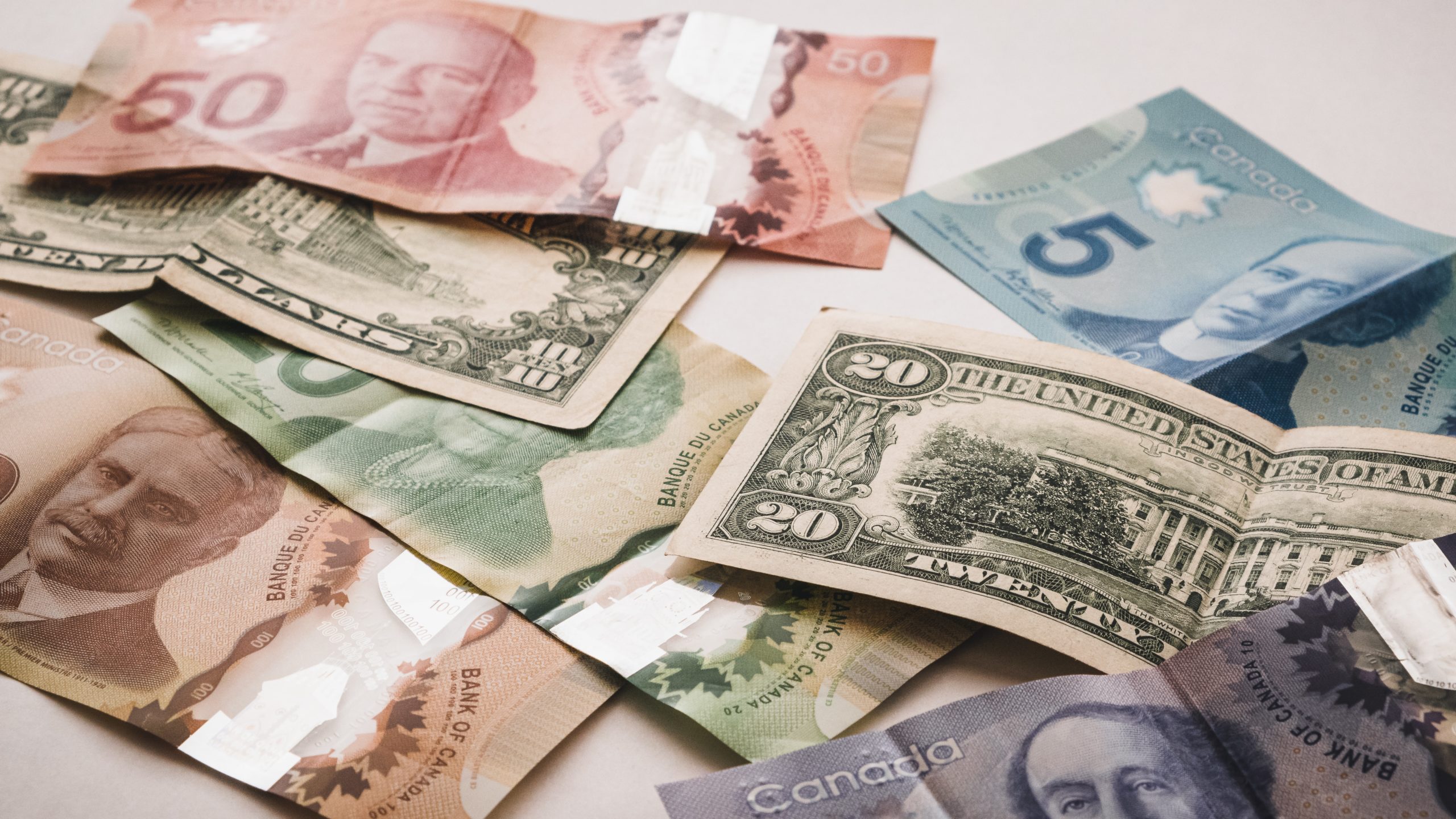 Un groupe de billets d'un dollar canadien sur une surface blanche, adapté aux investissements.