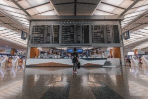 Man standing in front of departure table in an airport